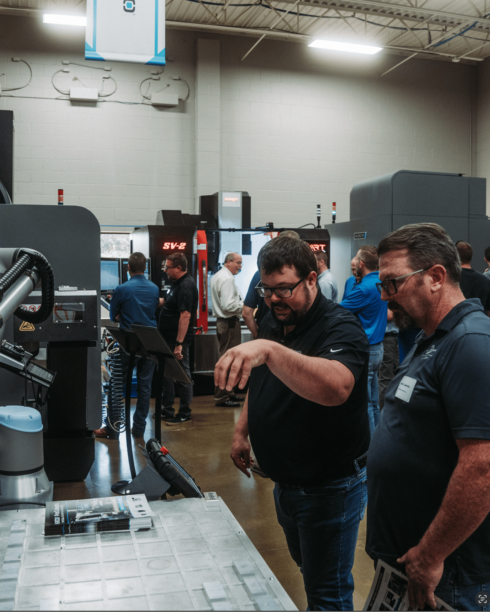 Two men are looking at a machine in the Reynolds Machinery showroom Two men are looking at a machine in the Reynolds Machinery showroom